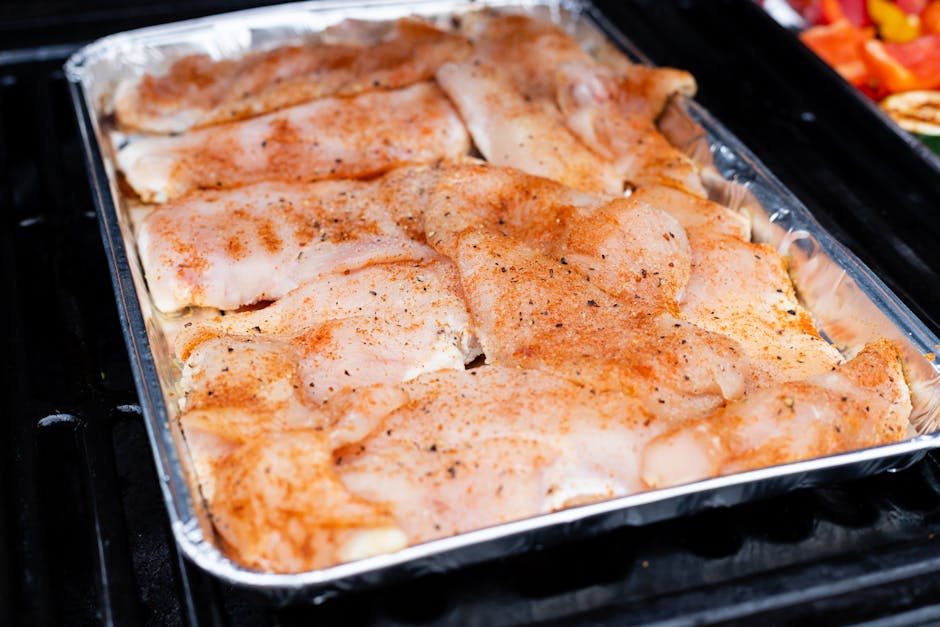 Seasoned Chicken Breasts and Thighs on Aluminum Tray